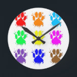 Relógio Redondo Padrão de Pata do Cachorro de Tinta<br><div class="desc">Um padrão colorido de estampas de pata de cão com efeito de estribo de tinta.</div>