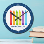 Relógio Redondo Sala de aula personalizada de professores de jardi<br><div class="desc">Uma bela Semana de Apreciação de Professores ou presente de fim de ano para uma aula de jardim de infância dar a seu professor primário. O relógio personalizado com o nome personalizado em azul. Personalize com seu nome ou texto sob o arco-íris fofo de lápis. Um presente adorável para um...</div>
