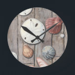 Relógio Redondo Tesouros em terra firme<br><div class="desc">Megan Meagher é conhecida por suas simples peças de arte. Esta imagem captura a simplicidade dos tesouros da costa, incluindo dólares de areia e conchas em tom pastel. Meagher engloba um fundo de madeira em sua imagem para contrastar esses tesouros. Compre este impressão de arte hoje sobre a cor de...</div>