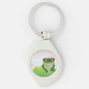 Sapo verde atrás do chaveiro de metal lírio