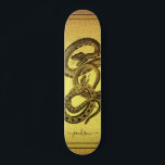 Skate Cobras Personalizados Folha de Papel Ouro<br><div class="desc">Um skate exclusivo com dois cobras enredados e seu nome personalizado em uma assinatura de script em um fundo falso de folha de ouro. captura de olhos e negrito.</div>