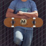 Skate Monograma Dourado de Couro Sable Moderno<br><div class="desc">Um design de monograma moderno com tipografia clássica de blocos,  inicial num emblema de ouro embebido em metal em tendências,  com o seu nome abaixo,  num pano de fundo de couro castanho liso.</div>