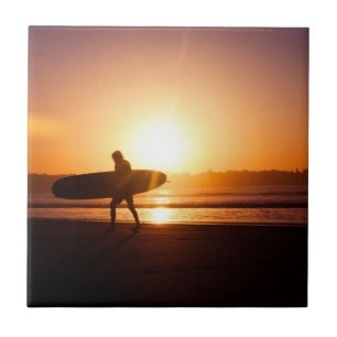 Surfista na praia no por do sol