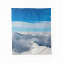 Montanhas que emergem de nuvens