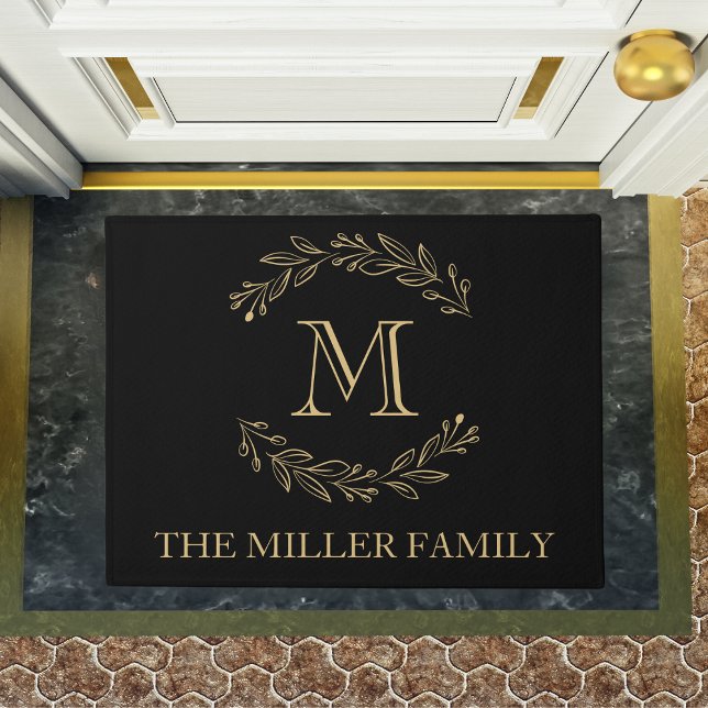 Tapete Monograma do nome da família Dourada Wreath Elegan (Elegant Black Gold Wreath Family Name Monogram Doormat)