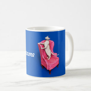 Um gato oriental numa caneca de café em poltrona